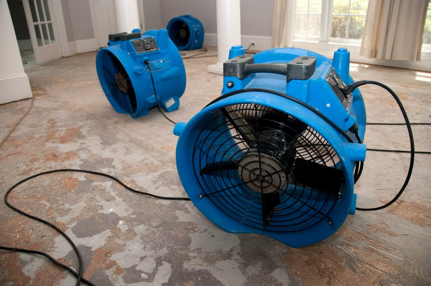 Fans on a damp floor that was previously flooded